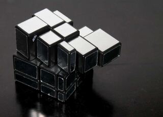 Polished metal cubes stacked on a black surface